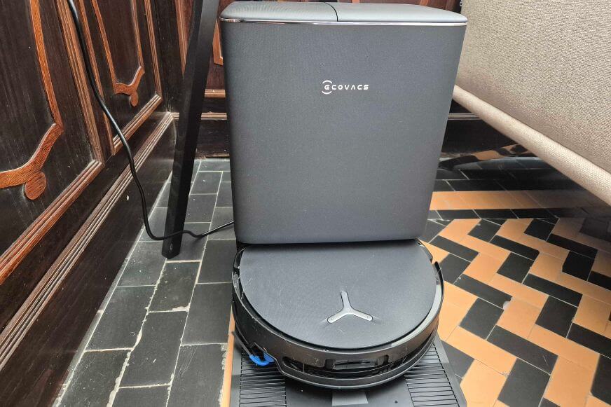 ECOVACS DEEBOT T90 PRO OMNI mit flachem Design in der Station im Test im Wohnzimmer nebene einer Couch